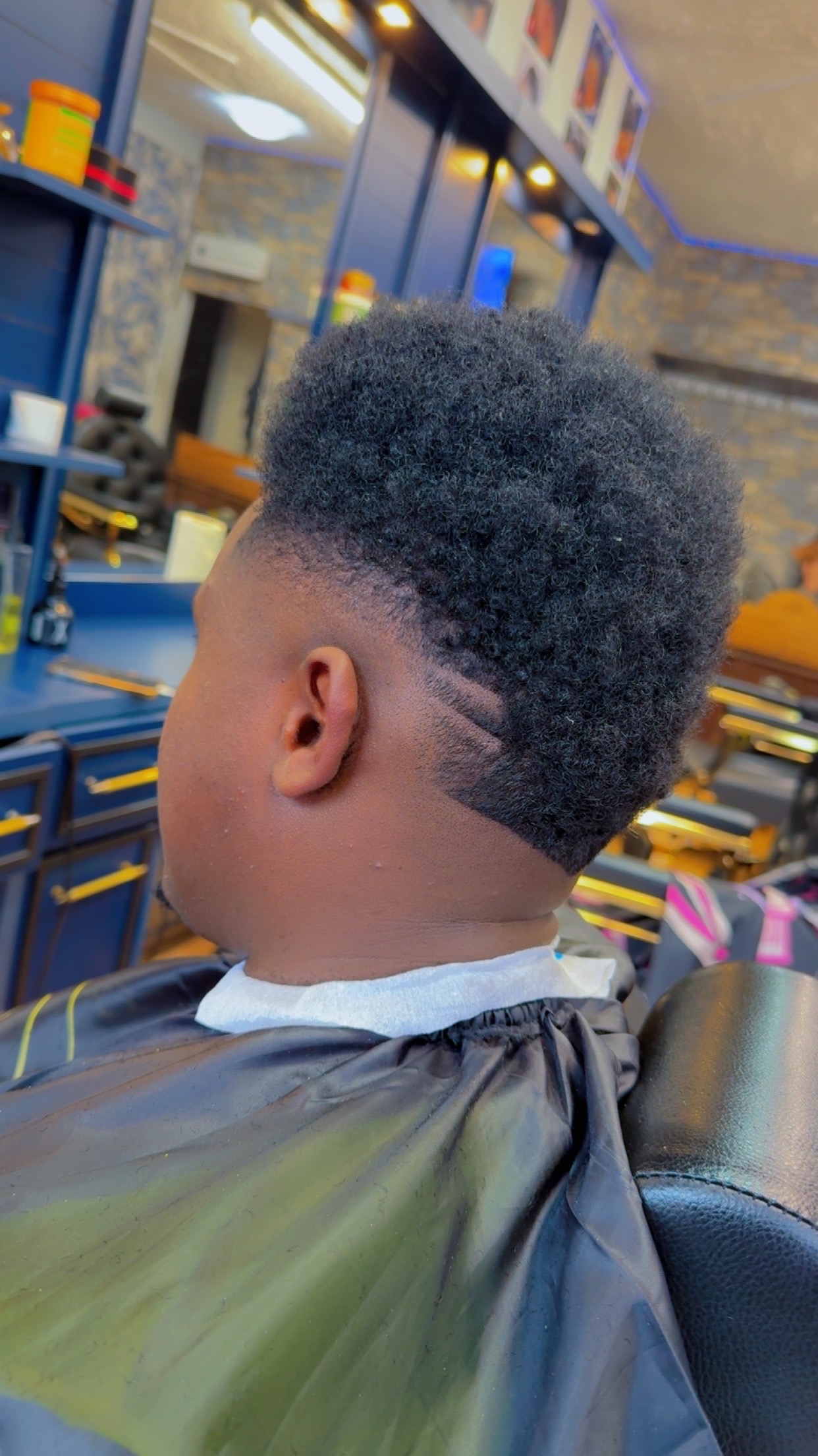 Afro taper with a clean shape-up, side profile